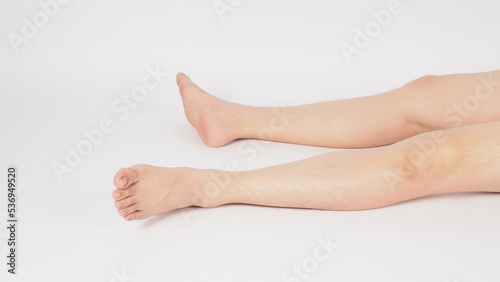 Asian Male legs and barefoot lie down on the white background.