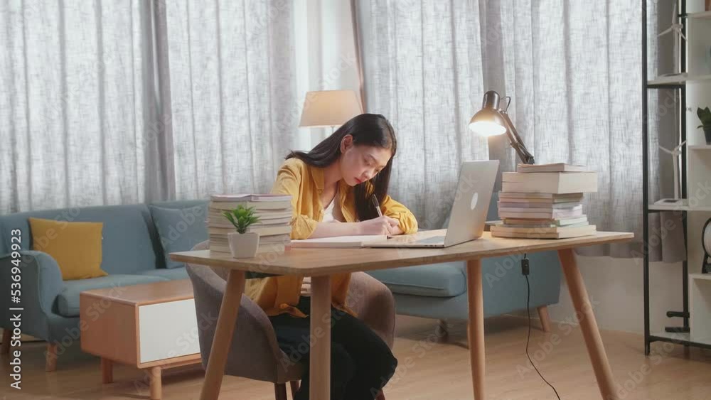Young Asian Female Writing On The Book While Studying On A Laptop At Home
Young Asian Female Writing On The Book While Studying On A Laptop At Home