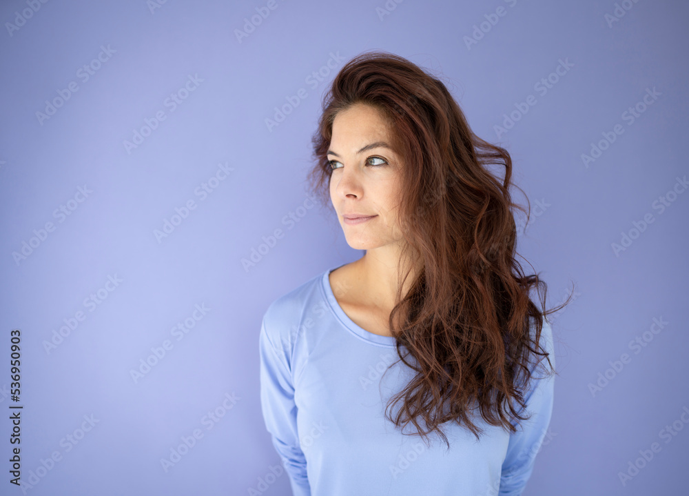 athletic woman with purple shirt in front of purple background with long dark hair athletic woman with purple shirt in front of purple background with long dark hair
