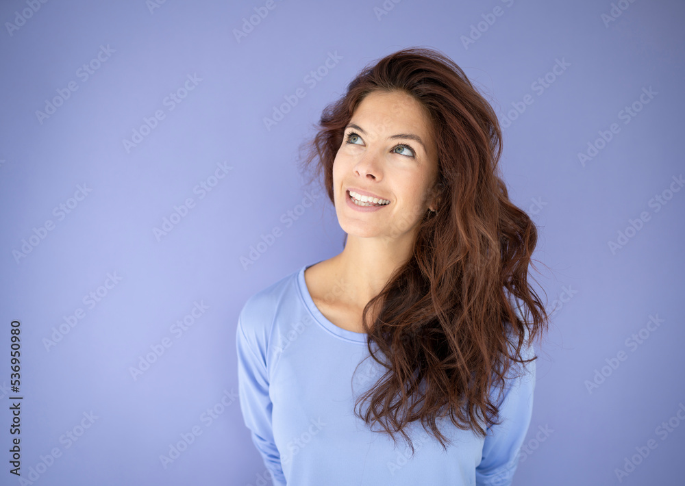 athletic woman with purple shirt in front of purple background with long dark hair athletic woman with purple shirt in front of purple background with long dark hair