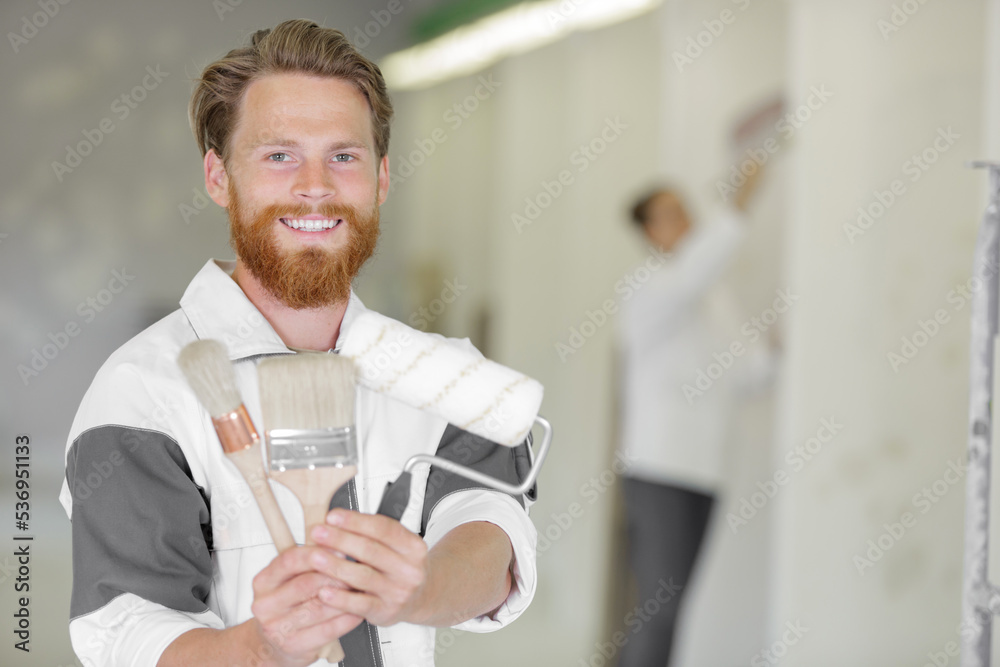 men with brush and roller smiling at camera men with brush and roller smiling at camera