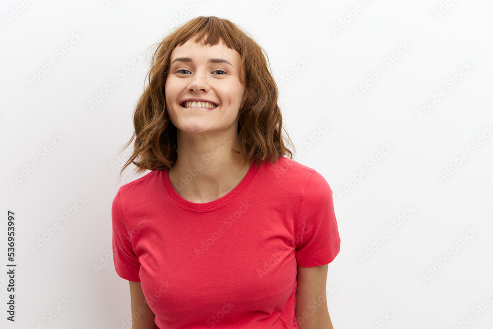 a sweet, pleasant, happy red-haired woman stands on a white background and smiles broadly looking away. Horizontal photo with an empty space for inserting an advertising layout a sweet, pleasant, happy red-haired woman stands on a white background and smiles broadly looking away. Horizontal photo with an empty space for inserting an advertising layout