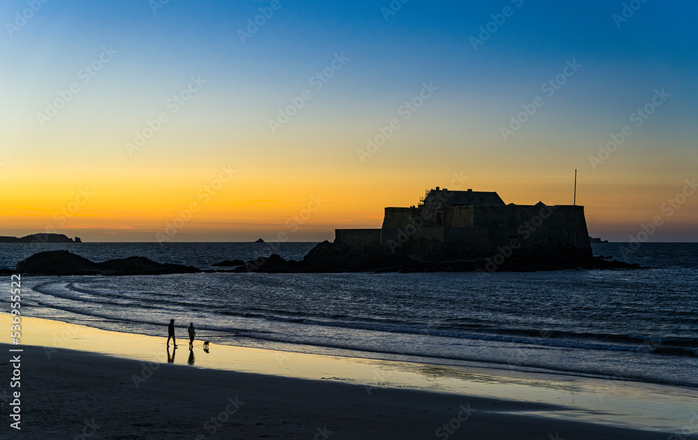 View of the beach du Sillon at sunset with the National Fort in the background in the medieval town of Saint Malo.