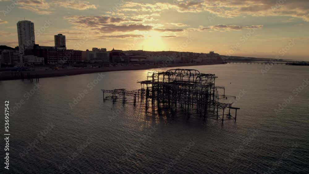 Drone descends behind West Pier Brighton as sun rises behind Drone descends behind West Pier Brighton as sun rises behind