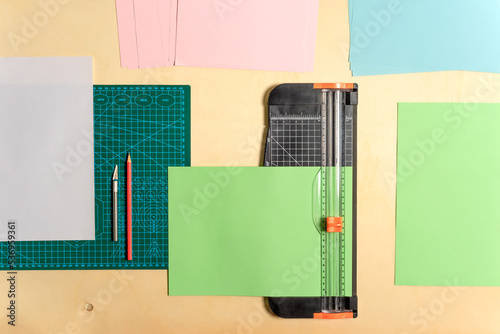  cutting paper with a guillotine, on a craft work table
