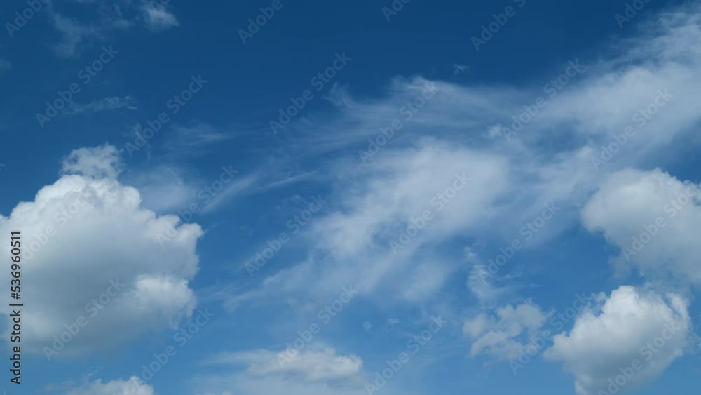 Blue clear sky with white cumulus and cirrus on different layers spindrift clouds background. Light white cirrus clouds in blue sky on a summer day. Timelapse. Blue clear sky with white cumulus and cirrus on different layers spindrift clouds background. Light white cirrus clouds in blue sky on a summer day. Timelapse.