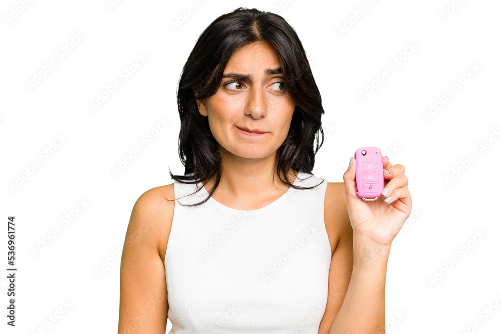 Young Indian woman holding a car keys isolated confused, feels doubtful and unsure. Young Indian woman holding a car keys isolated confused, feels doubtful and unsure.