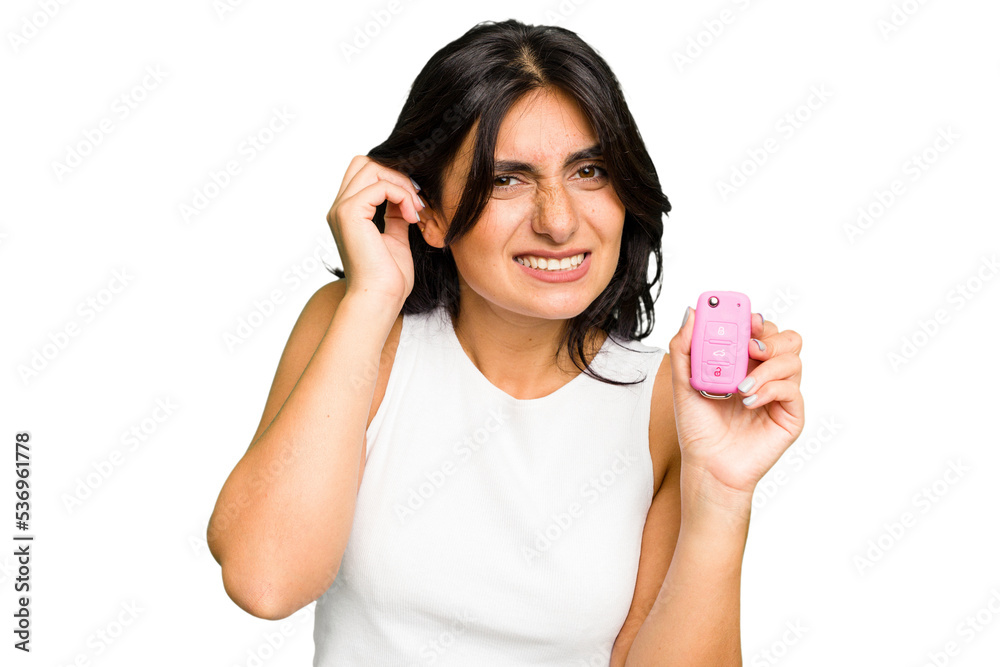 Young Indian woman holding a car keys isolated covering ears with hands. Young Indian woman holding a car keys isolated covering ears with hands.