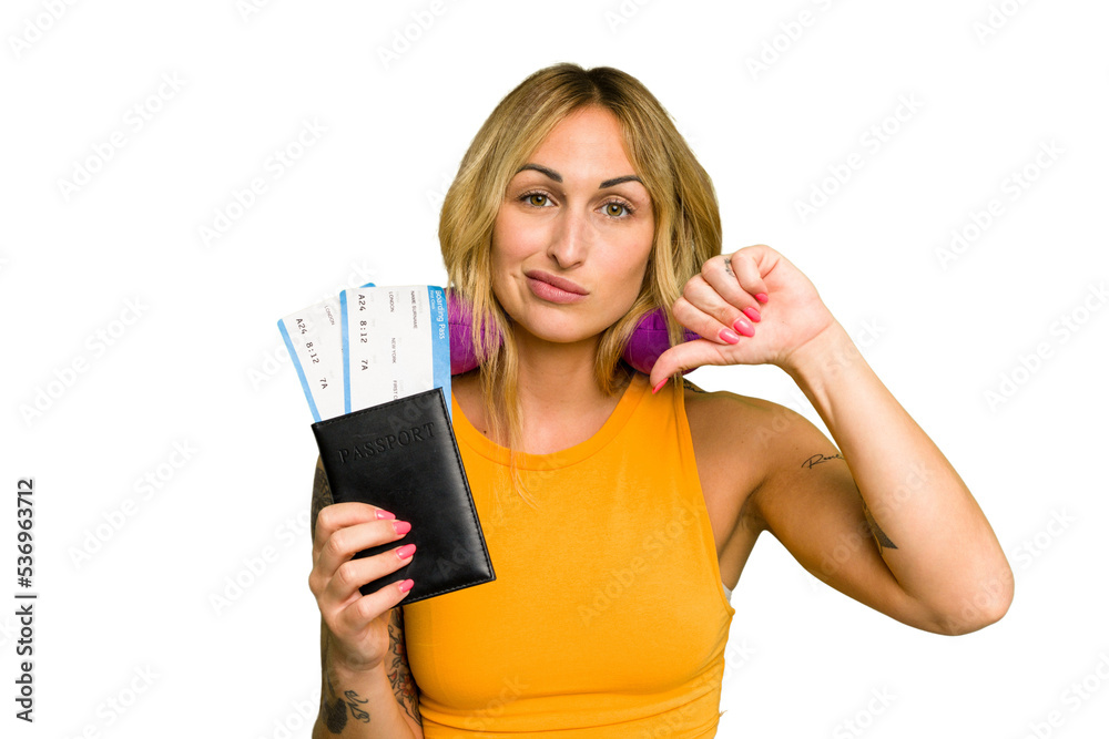 Young caucasian woman with inflatable travel pillow holding passport isolated on green chroma background showing a dislike gesture, thumbs down. Disagreement concept. Young caucasian woman with inflatable travel pillow holding passport isolated on green chroma background showing a dislike gesture, thumbs down. Disagreement concept.