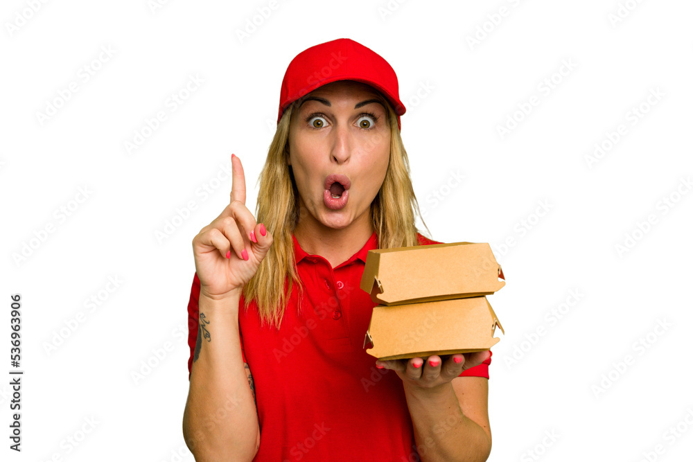Young caucasian delivery woman holding a burger isolated on green chroma background having some great idea, concept of creativity. Young caucasian delivery woman holding a burger isolated on green chroma background having some great idea, concept of creativity.