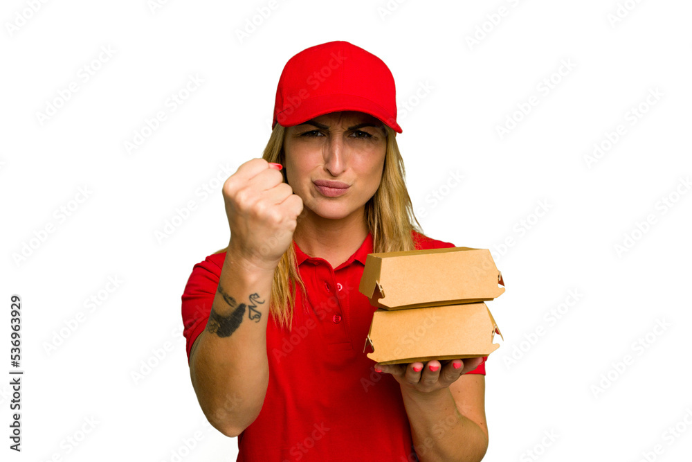 Young caucasian delivery woman holding a burger isolated on green chroma background showing fist to camera, aggressive facial expression. Young caucasian delivery woman holding a burger isolated on green chroma background showing fist to camera, aggressive facial expression.
