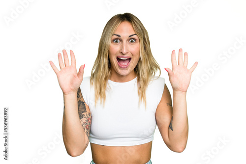 Young caucasian woman isolated on green chroma background celebrating a victory or success, he is surprised and shocked.