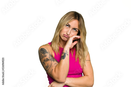 Young caucasian woman isolated on green chroma background tired of a repetitive task.