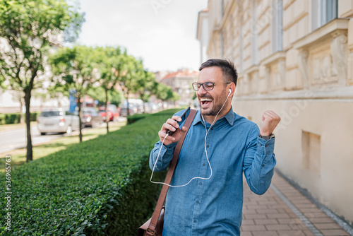 Canvastavla Enthusiastic young adult entrepreneur business man, listening to music, singing and dancing outside