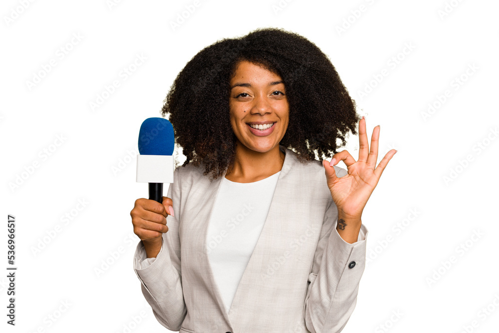 Young TV presenter African American woman with a microphone isolated cheerful and confident showing ok gesture. Young TV presenter African American woman with a microphone isolated cheerful and confident showing ok gesture.