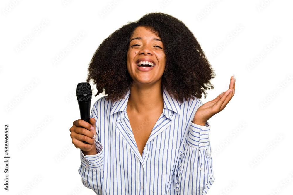 Young African American singer woman holding a microphone isolated receiving a pleasant surprise, excited and raising hands. Young African American singer woman holding a microphone isolated receiving a pleasant surprise, excited and raising hands.
