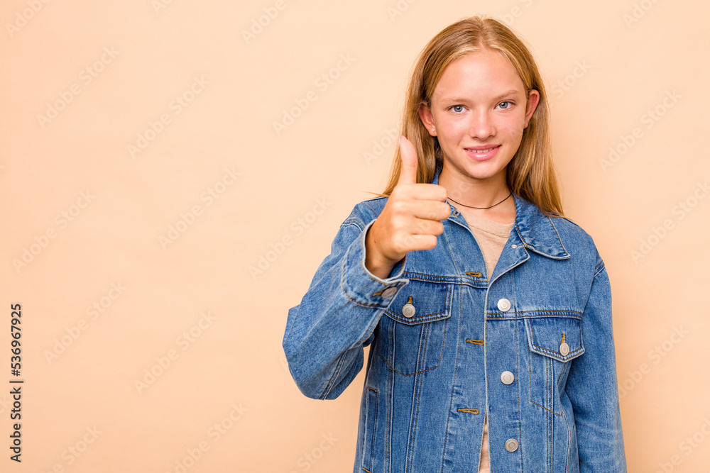 Caucasian teen girl isolated on beige background smiling and raising thumb up Caucasian teen girl isolated on beige background smiling and raising thumb up