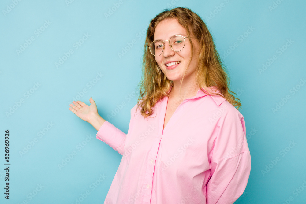 Young caucasian woman isolated on blue background showing a welcome expression. Young caucasian woman isolated on blue background showing a welcome expression.