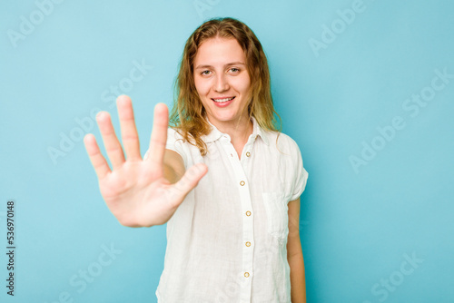 Young caucasian woman isolated on blue background smiling cheerful showing number five with fingers.