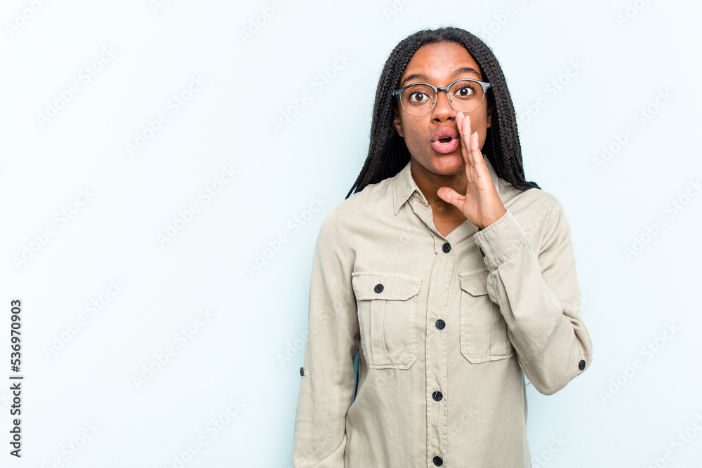 Young African American woman with braids hair isolated on blue background is saying a secret hot braking news and looking aside Young African American woman with braids hair isolated on blue background is saying a secret hot braking news and looking aside
