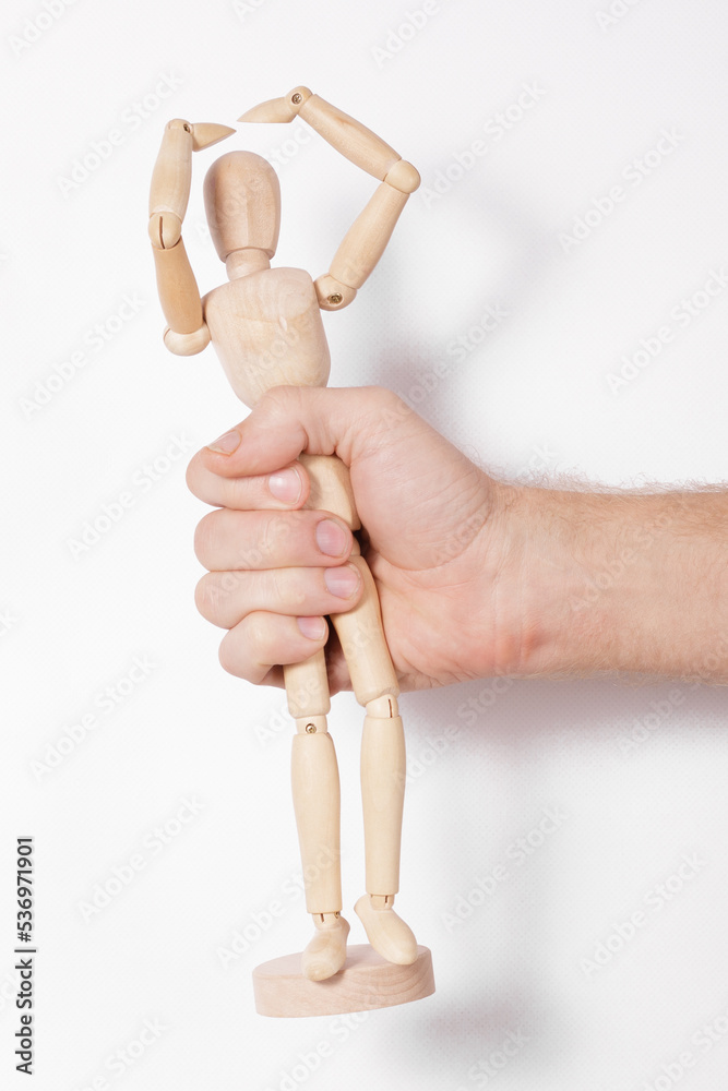 male hand holding a wooden puppet isolated on white