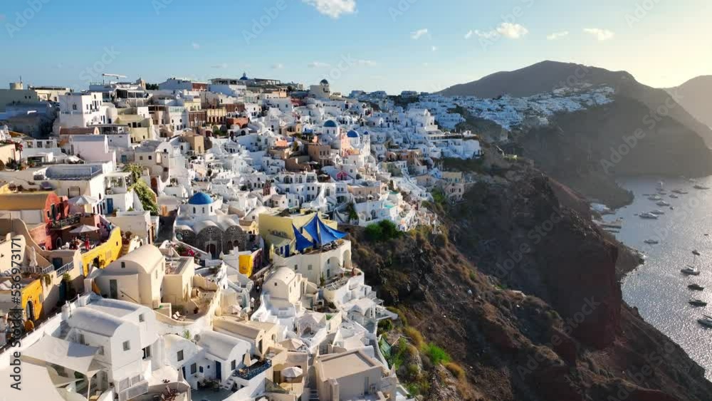 Famous Greek island of Santorini and the town of Thira at sunrise, aerial view of popular resort in Greece, flying above colourful houses of Thira, amazing romantic town in Greece