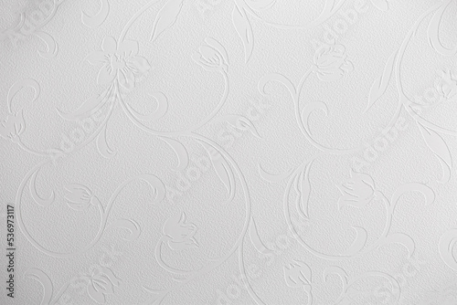 Light background of decorative plaster with abstract spots. Unusual texture of white or gray wall with beautiful patterns, creative surface background. Finishing coating for building cladding.
