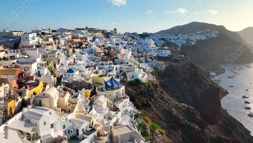 Famous Greek island of Santorini and the town of Thira at sunrise, aerial view of popular resort in Greece, flying above colourful houses of Thira, amazing romantic town in Greece