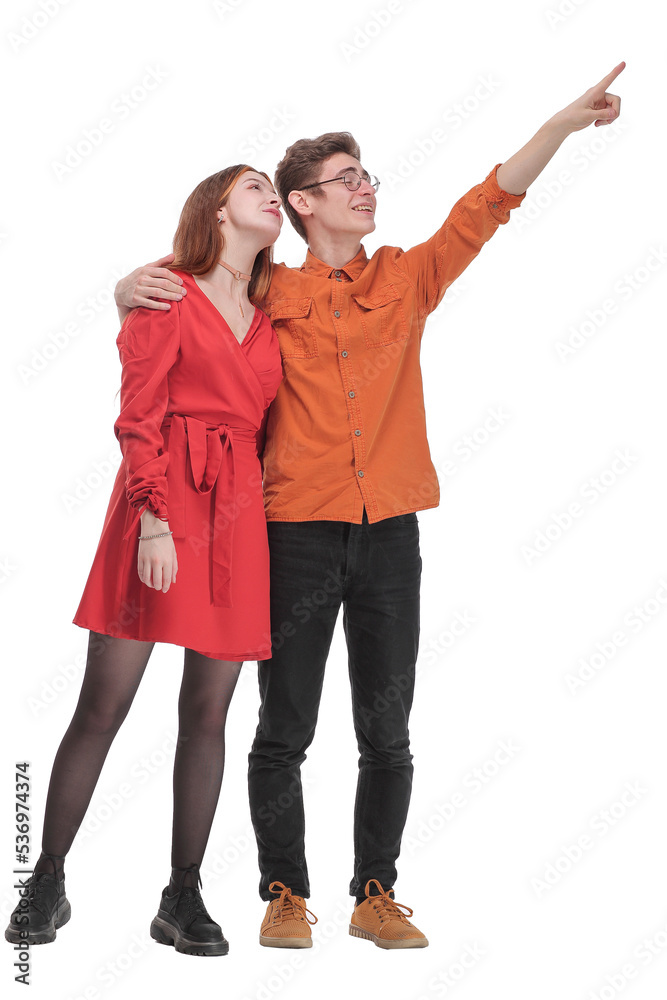Young cute couple embracing and pointing on white background Young cute couple embracing and pointing on white background