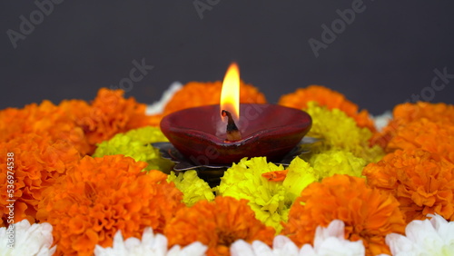Happy Diwali. Traditional symbols of Indian festival of light. Burning diya oil lamps and flowers on red background. Copy space.