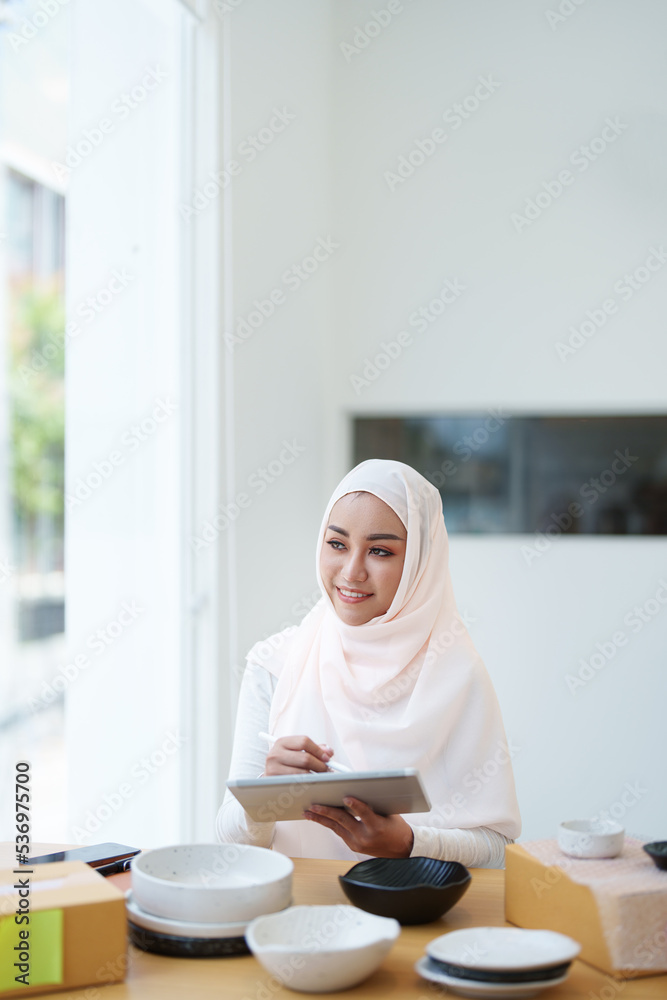 Beautiful Muslim woman selling online at home, business owner, business sme concepts Beautiful Muslim woman selling online at home, business owner, business sme concepts