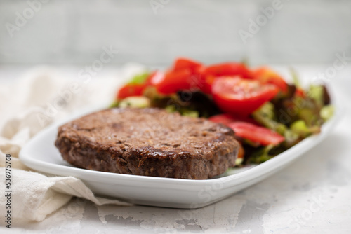 three fried ground meat with fresh salad on white plate