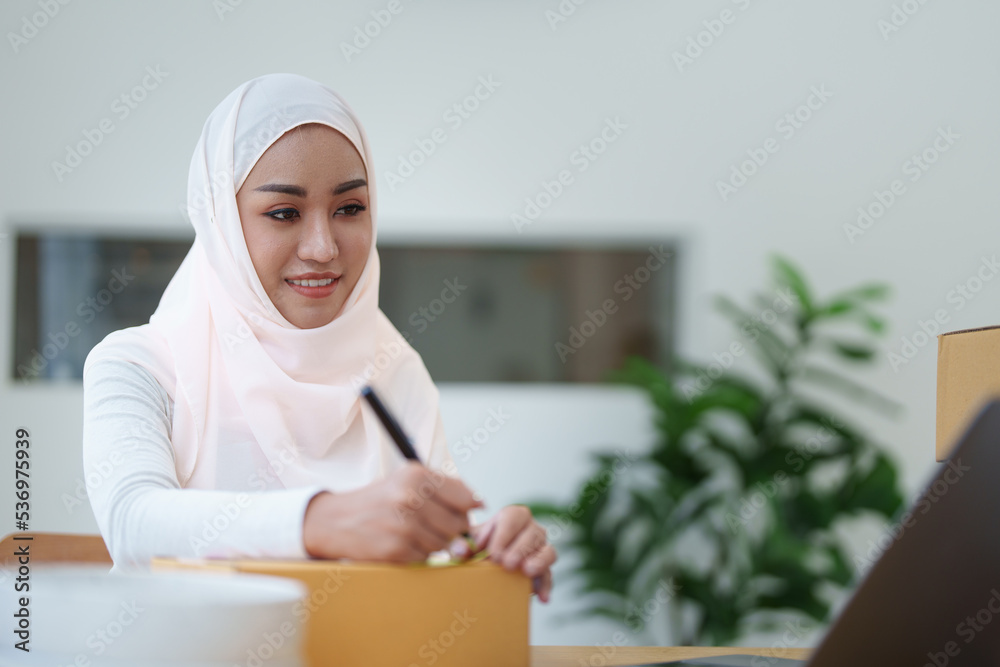 Beautiful Muslim woman selling online at home, business owner, business sme concepts Beautiful Muslim woman selling online at home, business owner, business sme concepts