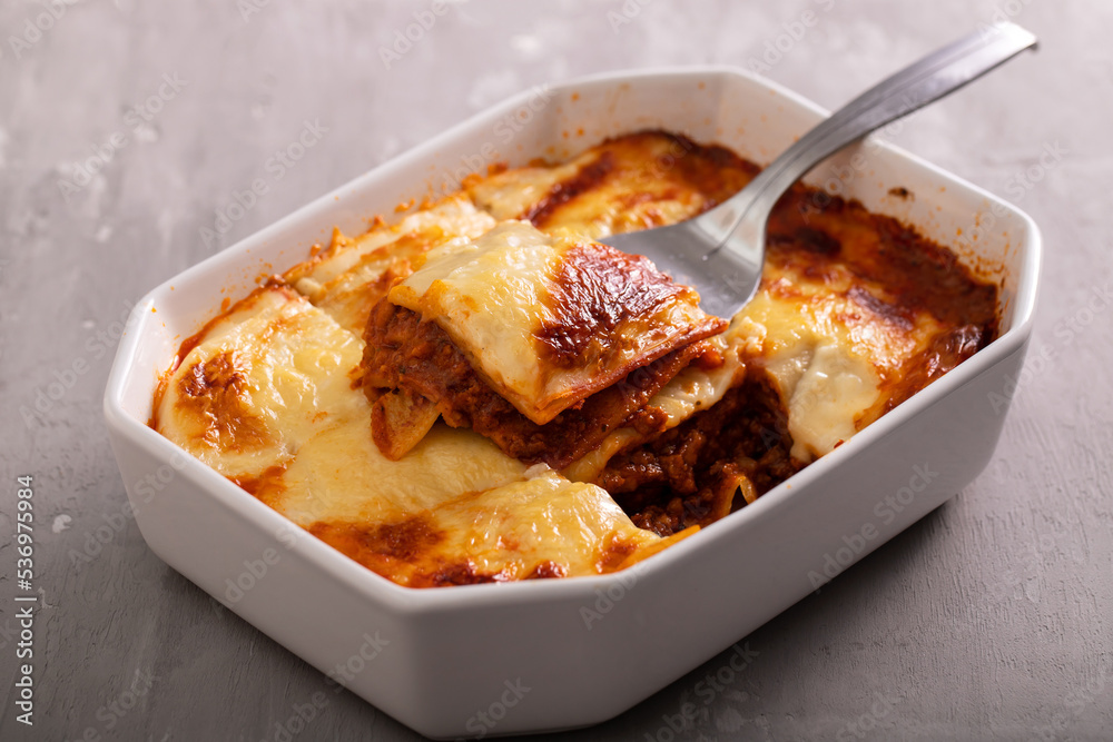 Fresh lasagna with meat and tomato sauce baked in the oven in a ceramic dish. Fresh lasagna with meat and tomato sauce baked in the oven in a ceramic dish.