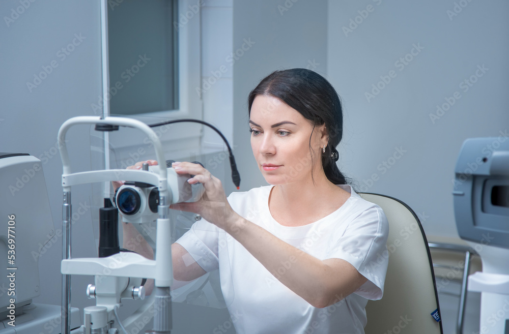 an optometrist checks his eyesight with a slit lamp. The concept of biomicroscopy of the eye an optometrist checks his eyesight with a slit lamp. The concept of biomicroscopy of the eye