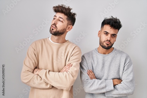Young homosexual couple standing over white background looking sleepy and tired, exhausted for fatigue and hangover, lazy eyes in the morning.