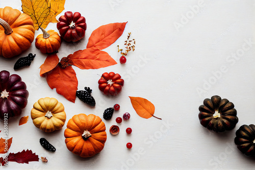 Autumn background of fallen leaves, berries and pumpkins on a white wooden background. Halloween day concept. 3d illustration