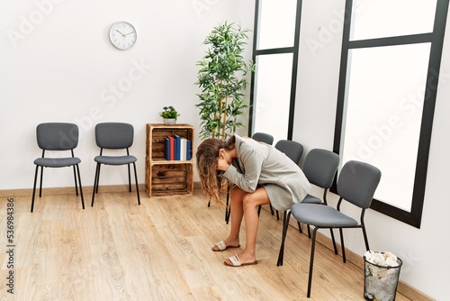 Young beautiful hispanic woman sitting on chair with stressed expression at waiting room