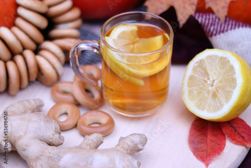 Autumn tea, warming vitamin drink with lemon and ginger. Autumn mood, composition with ripe pumpkins, bagels and lemon tea