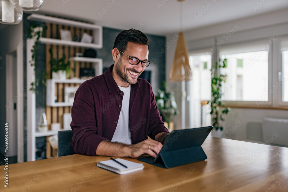 Smiling businessman, dressed casually, working over the digital tablet. Smiling businessman, dressed casually, working over the digital tablet.