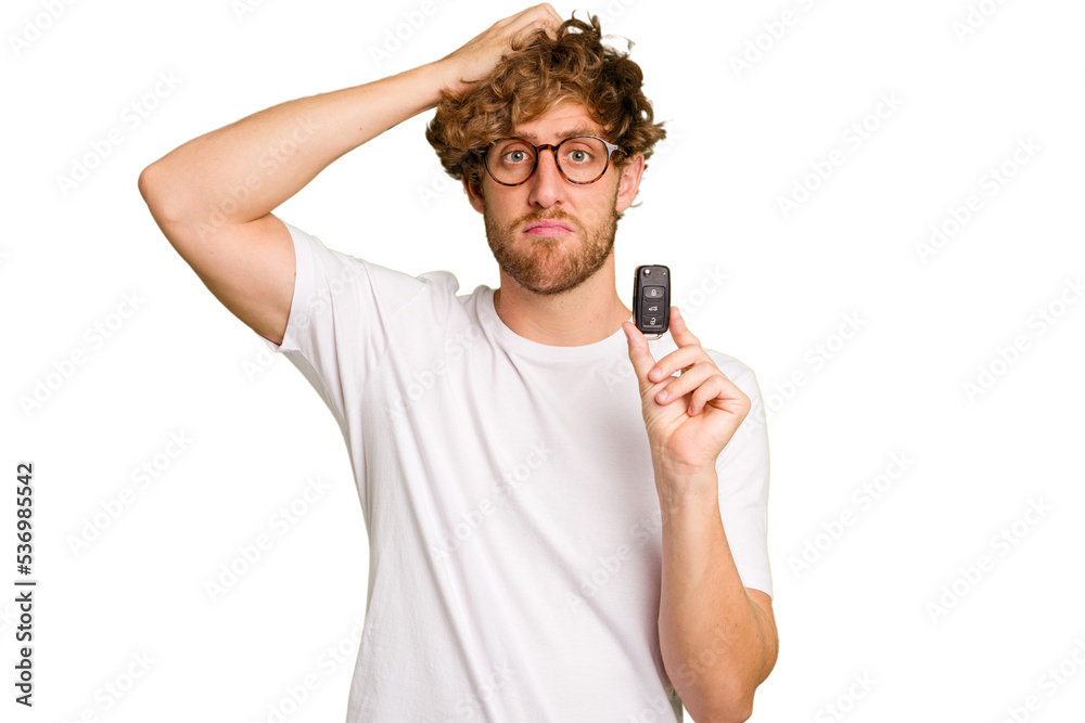 Young caucasian man holding car keys isolated on white background being shocked, she has remembered important meeting. - obrazy, fototapety, plakaty 