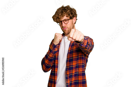 Young caucasian man isolated on green chroma background throwing a punch, anger, fighting due to an argument, boxing.