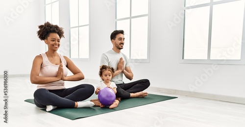 Couple and daughter smiling confident training yoga at sport center © Krakenimages.com