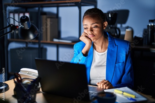 Beautiful african american woman working at the office at night thinking looking tired and bored with depression problems with crossed arms.