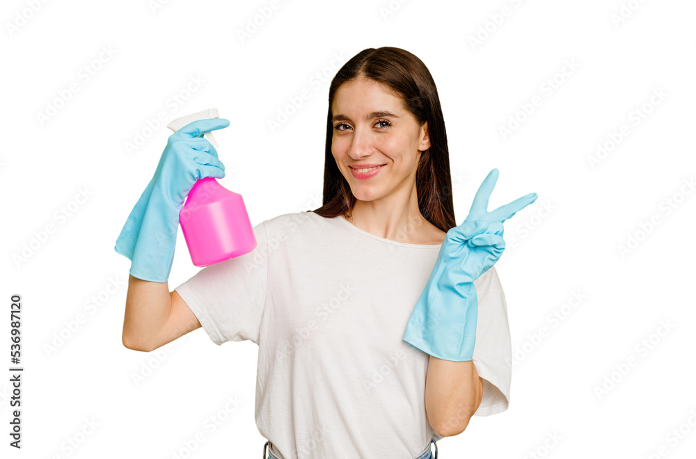 Young cleaner woman isolated joyful and carefree showing a peace symbol with fingers. Young cleaner woman isolated joyful and carefree showing a peace symbol with fingers.