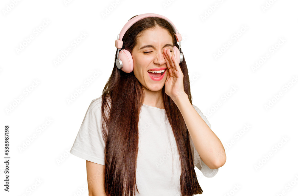 Young caucasian woman wearing headphones isolated shouting and holding palm near opened mouth. Young caucasian woman wearing headphones isolated shouting and holding palm near opened mouth.