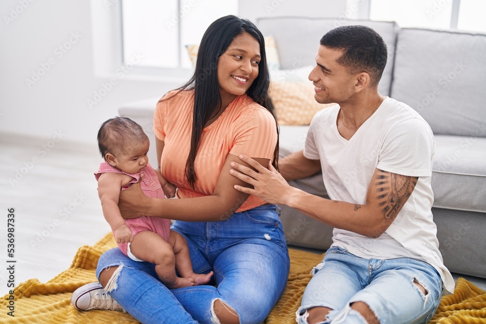 Hispanic family hugging each other sitting on sofa at home Hispanic family hugging each other sitting on sofa at home
