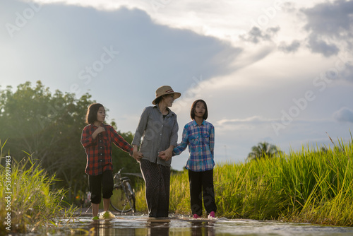 Mother and daughter are asian family walking and looking flooding in rural