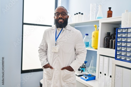 Young african american man wearing scientist uniform standing at laboratory