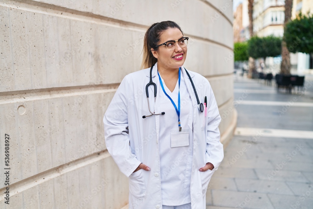 Young beautiful plus size woman doctor smiling confident standing at hospital Young beautiful plus size woman doctor smiling confident standing at hospital